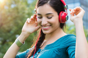 Closeup shot of young woman listening to music in a park. Portra
